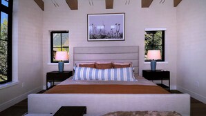 A bedroom with a large bed, two bedside tables, a window, and a framed picture on the wall.