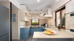 Una cocina moderna con armarios azules, piso estampado y un cuenco de frutas en la encimera.