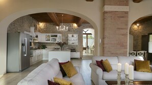 A spacious living area with a white sofa set, a wooden coffee table, and a kitchen in the background. - Exclusive luxury property with private pool in Siena countryside Borgo la Chiusa (Siena)