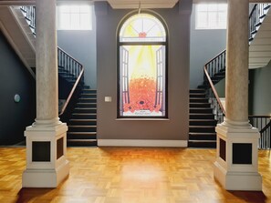 A grand staircase with marble columns, a large stained glass window, and a wooden parquet floor. - 2-bed Apartment, Parking Including, Sleeps 4 (Swindon)