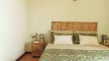 A neatly arranged bedroom with a bed, two nightstands, and a decorative headboard.