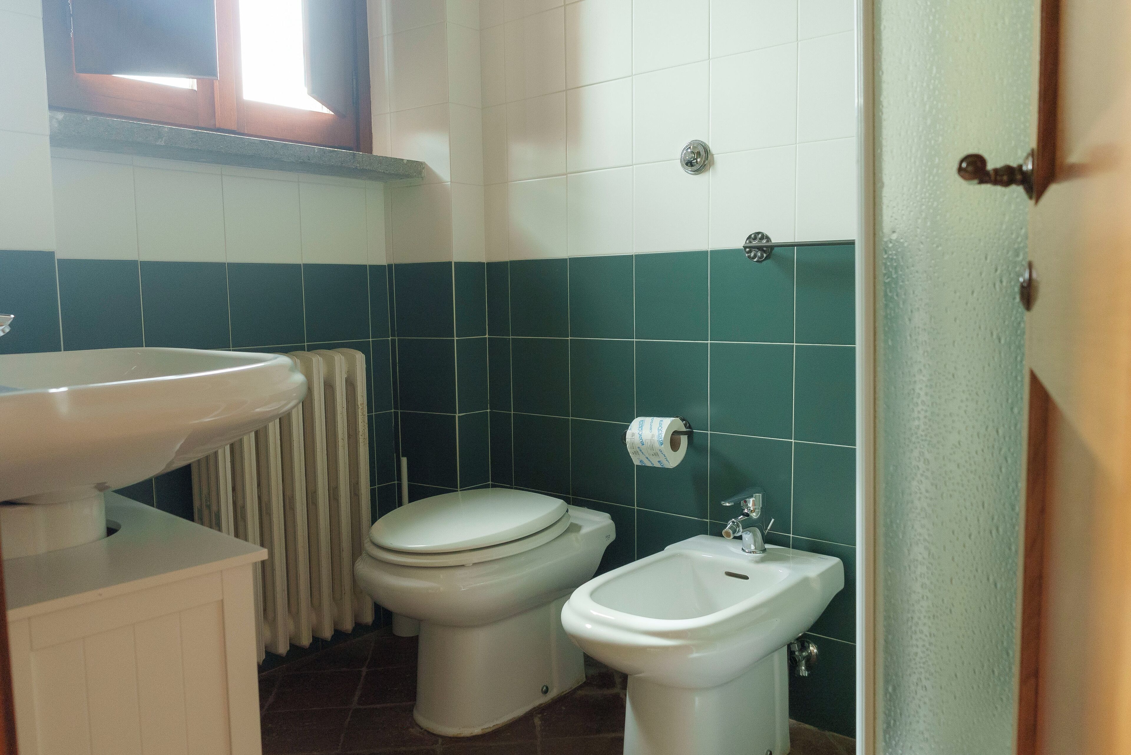 A bathroom with a white sink, a toilet, and a bidet.