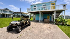 A two-story building with a covered porch and a golf cart parked in front.