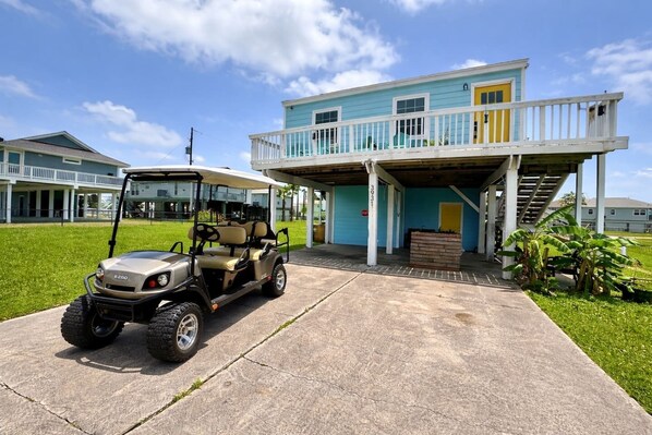 A two-story building with a covered porch and a golf cart parked in front. - Golf Cart/Pets Allowed/3m to Beach (Galveston)