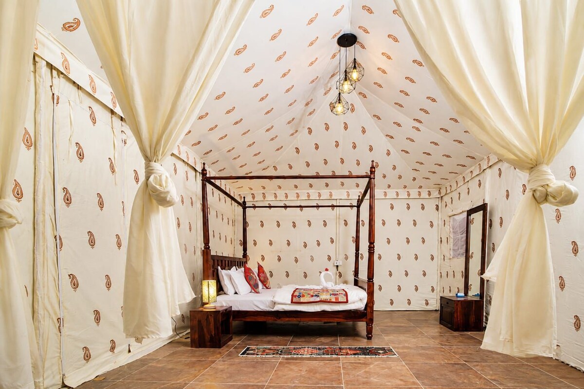 A four-poster bed with a wooden frame, a patterned wall, and a tiled floor.