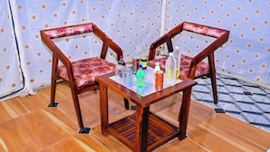 A wooden table with chairs, a tiled floor, and a curtain with a star pattern. -  Barkha Desert Safari Camp Sam Sand Dunes (Jaisalmer)