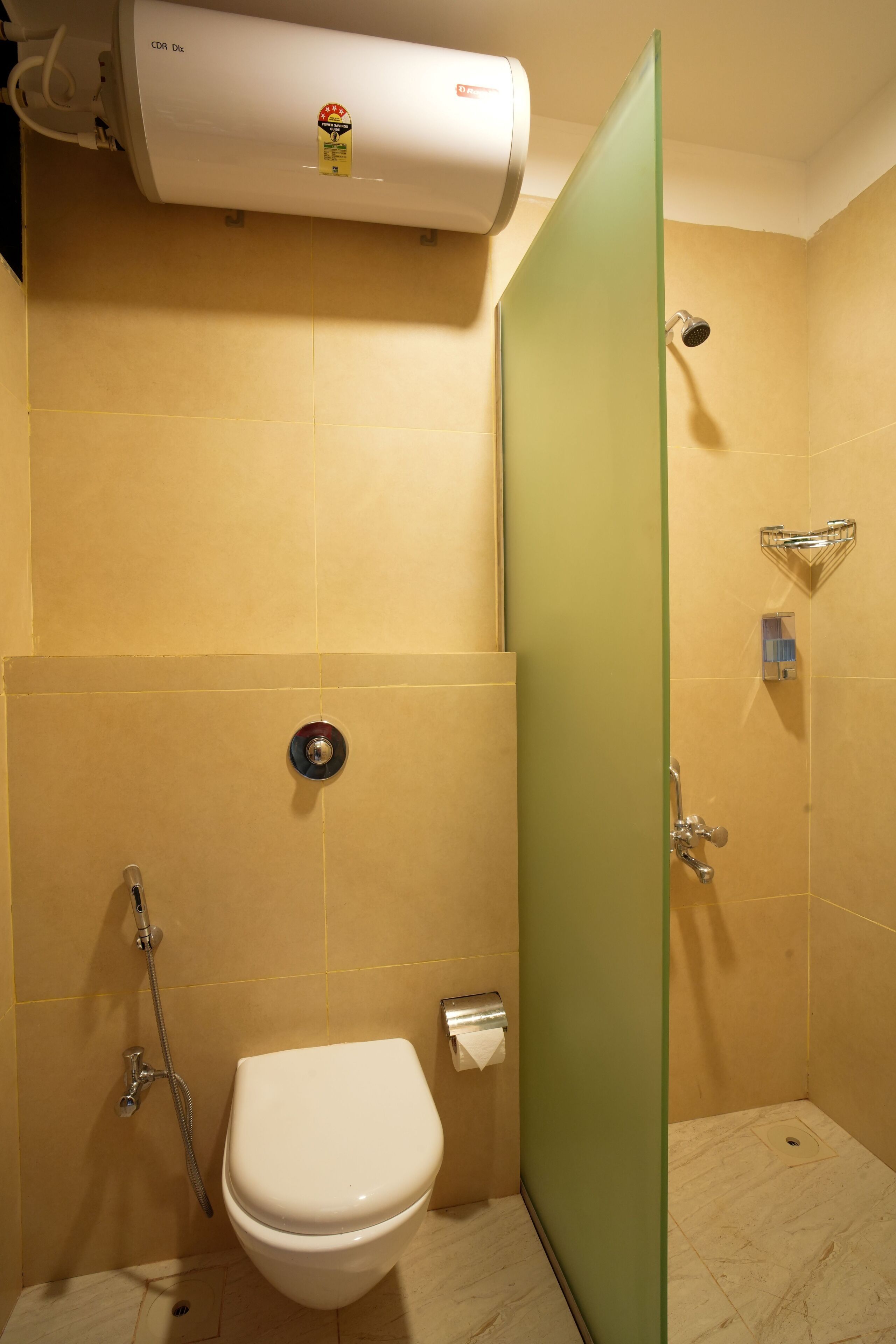 A bathroom with a toilet, a shower, and a glass partition.