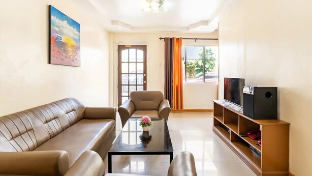 A living room with a sofa, armchairs, a coffee table, a TV, and a speaker. - WOW! 3BR House w/Karaoke ,Swimming Pool, Pet Friendly (Lapu-Lapu City)