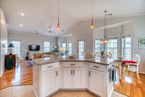 A spacious kitchen with a central island, white cabinetry, and pendant lighting. - Port Folio - Adorable 3 BR home with Covered Porch! (Surf City)