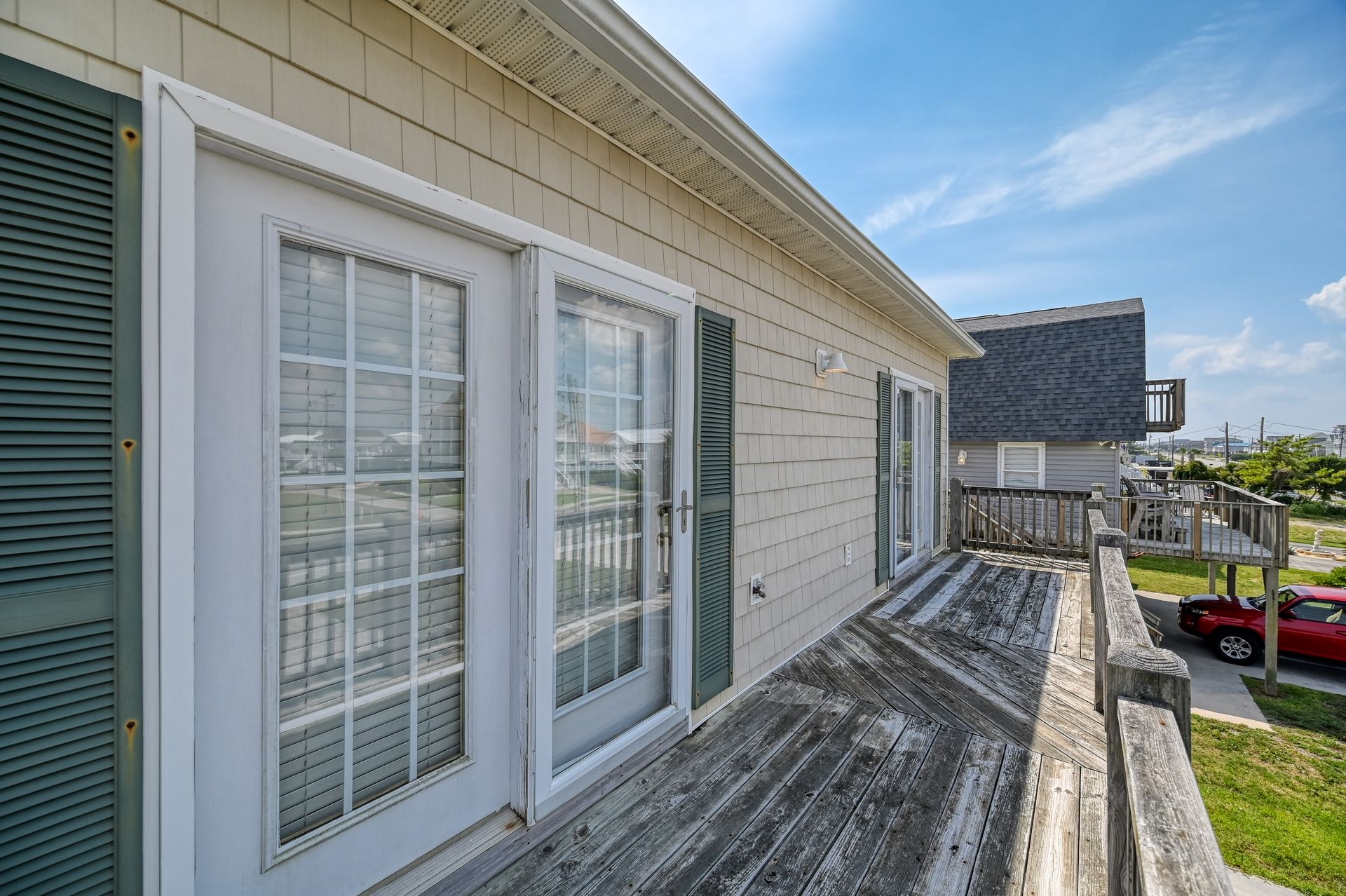 A residential property with a wooden deck, a garage, and a driveway.
