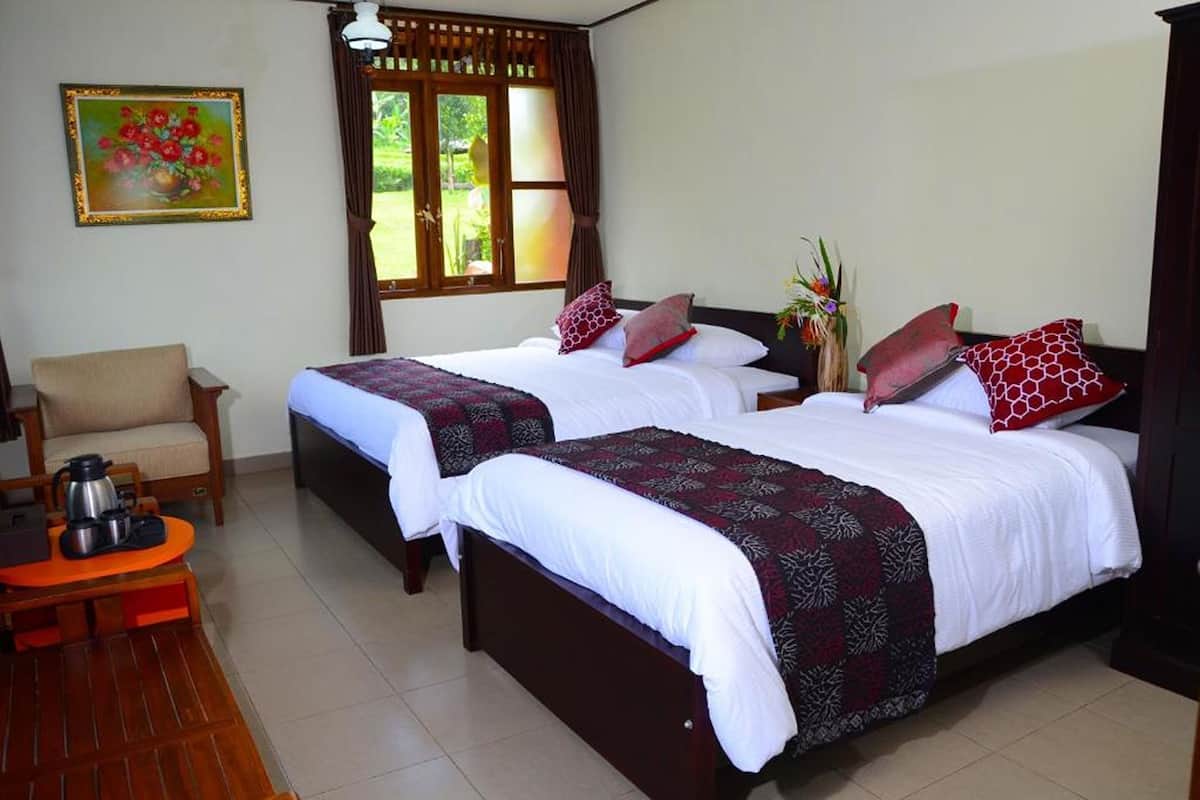 A hotel room with two beds, a wooden chair, a small table with a kettle, and a window with curtains.