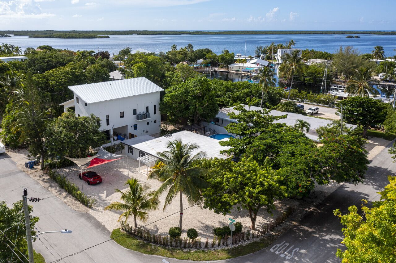 Una zona residencial costera con un edificio blanco, una piscina y vistas al mar.