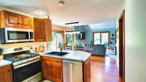 Una cocina moderna con armarios de madera, electrodomésticos de acero inoxidable y una isla central.