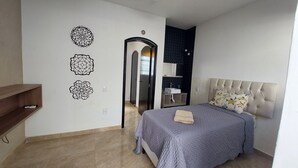 Une chambre à coucher comprenant un lit, une armoire, un miroir et des éléments décoratifs sur les murs.