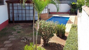 Un quartier résidentiel doté d’une piscine, de palmiers et d’un petit jardin.