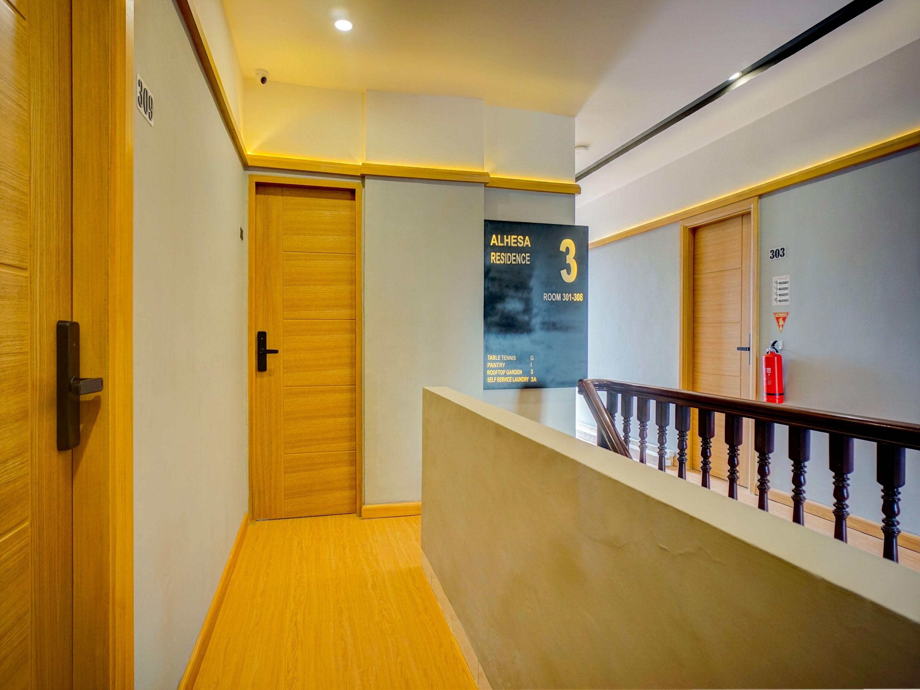A hallway with a wooden door, a sign indicating room 301-308, and a fire extinguisher on the wall.