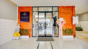The entrance to Alhesa Residence with a glass door, a brick facade, and a signboard. - Hotel O Alhesa Residence (Medan)