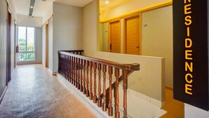 A hotel hallway with a wooden staircase, a large window, and a door marked "309". - Hotel O Alhesa Residence (Medan)