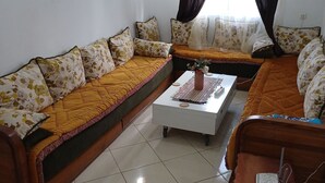 A living room with a sofa set, a coffee table, and a side table. - Super et Nouvel Appart Proche de la Plage (Skhirat)