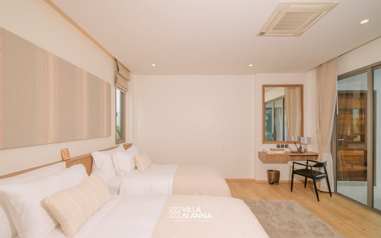 A modern hotel room with two beds, a small desk, a mirror, and a sliding glass door to the outside.