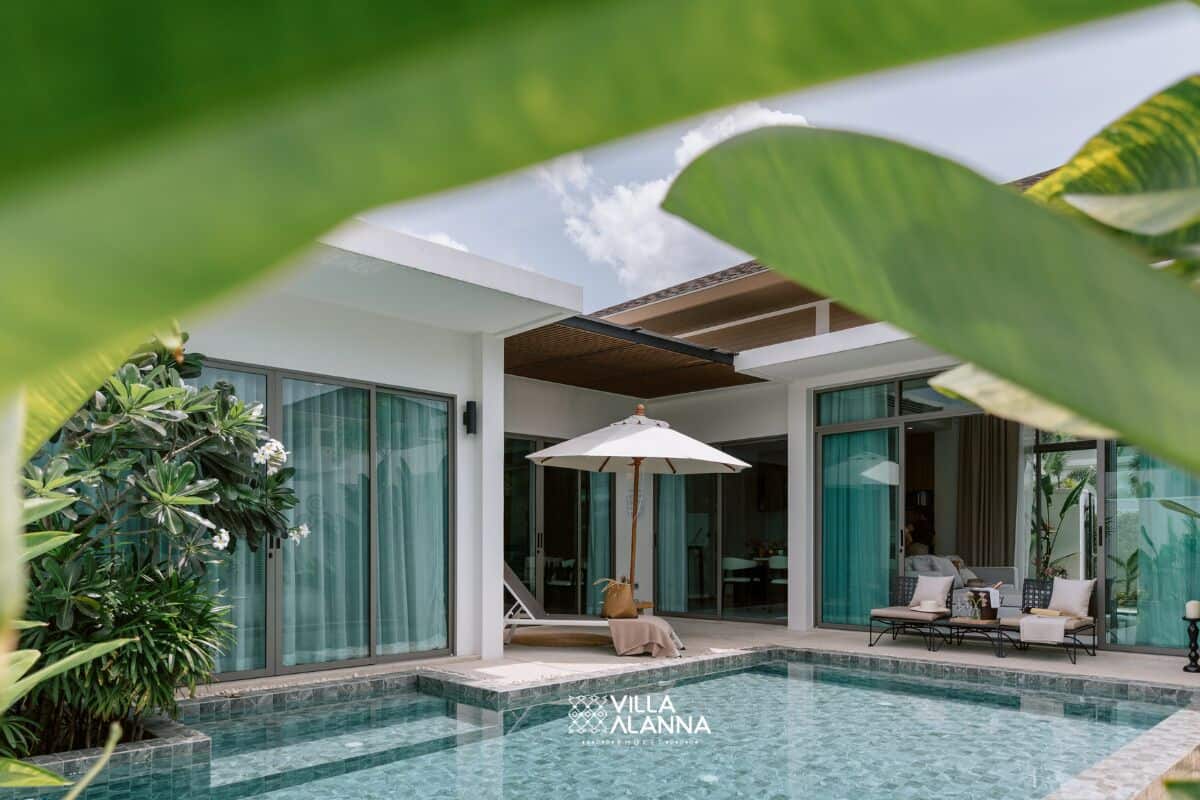 A modern villa with a swimming pool, large windows, and lush greenery.