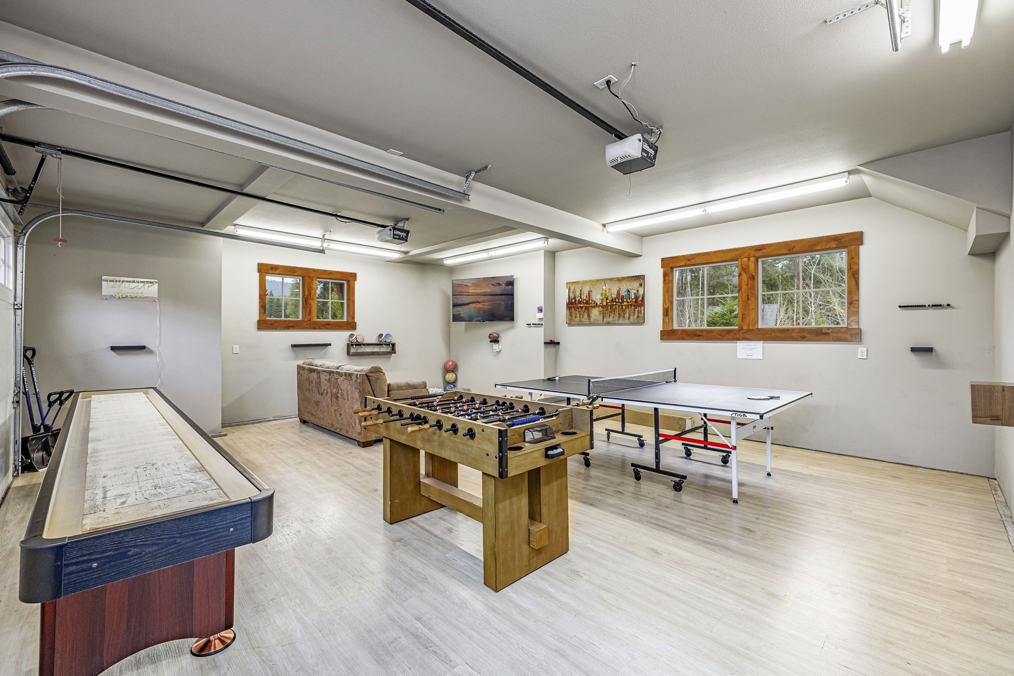 Una habitación con mesa de fútbol, mesa de ping pong y mesa de billar.