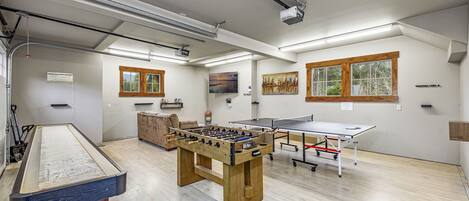 Una habitación con mesa de fútbol, mesa de ping pong y mesa de billar.