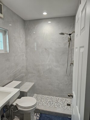 Un baño con inodoro, lavabo y ducha.