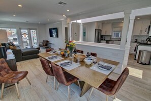 A modern dining area with a wooden table set for four, surrounded by leather chairs. - Springbreak Getaway 3BD/2BA, garage,2Bikes A View (newport beach)