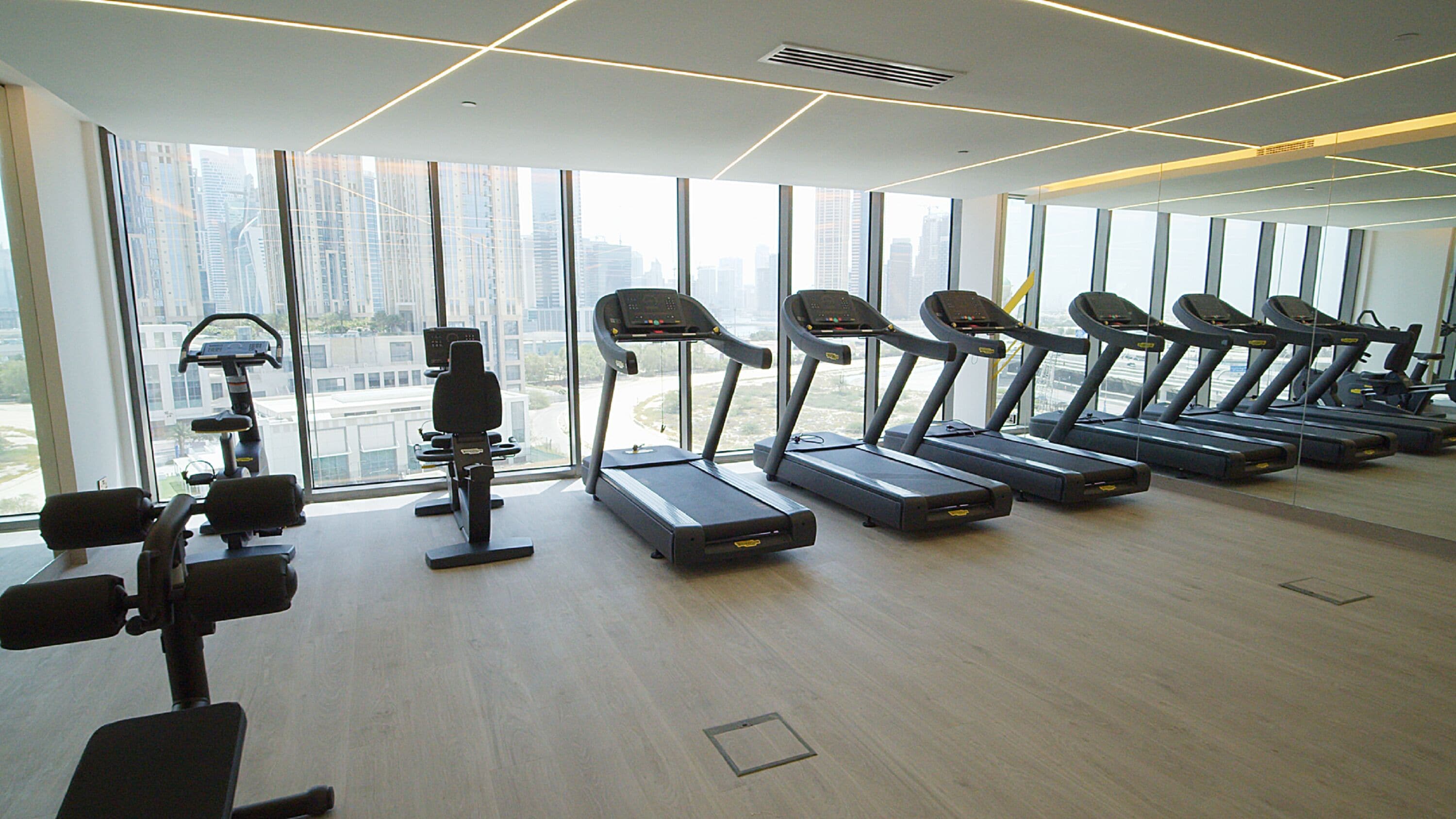Une salle de sport équipée de tapis de course, d’haltères et d’appareils d’exercice.