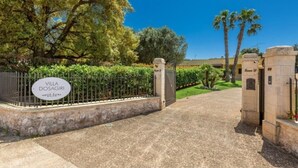 A gated entrance to Villa Dosagiri with a stone wall and a sign. - Villa Dosagiri Stanza Privata+piscina (Selva di Fasano)