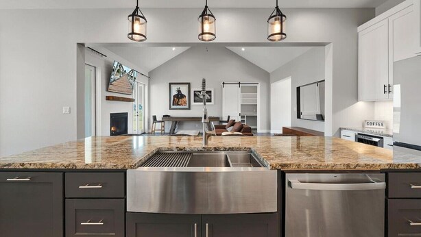 A modern kitchen with a large island, stainless steel appliances, and pendant lighting. - New! Luxury Texas Farmhouse (Waco)