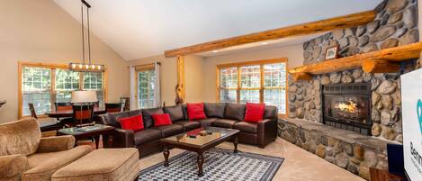 Cozy living room with a high ceiling, fireplace, and comfortable seating area.