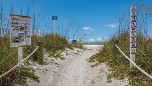 A beach path leading to the ocean with informational signs and a beach hours sign. - Luxurious bungalow in Longboat Key (Longboat Key)