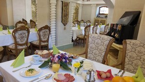A dining area with tables set for breakfast, including plates of food, drinks, and condiments. - Hotel U Zámečku Cihelny (Karlovy Vary)