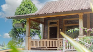 Une maison en bois avec un toit en tuiles, un balcon et une porte portant le numéro 6.
