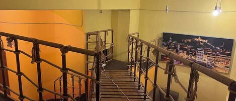 A wooden staircase with rope railings leading to a lower level.