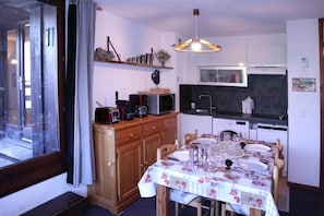 A compact kitchen with a dining table set for four, a microwave, and a coffee maker.