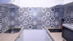 A kitchen with black and white patterned tiles, stainless steel sink, wooden countertops, and a microwave. - Ski-in/ski-out & foot of the slopes, 3rd floor, balcony, tv, ski locker, 30m², Les Orres (Les Orres)