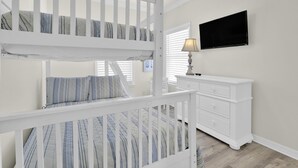 A bunk bed with a TV above it, a dresser, and a lamp. - Spinnaker Pointe 3b 3 Bedroom Duplex by RedAwning (Gulf Shores)