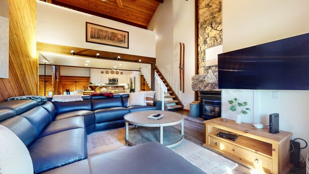 A modern living room with a sectional sofa, a coffee table, and a fireplace.