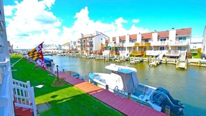 Un puerto deportivo con barcos amarrados, una bandera y edificios con balcones.
