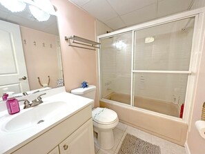 Ein Badezimmer mit Waschbecken, Spiegel, Toilette und einer Duschkabine.