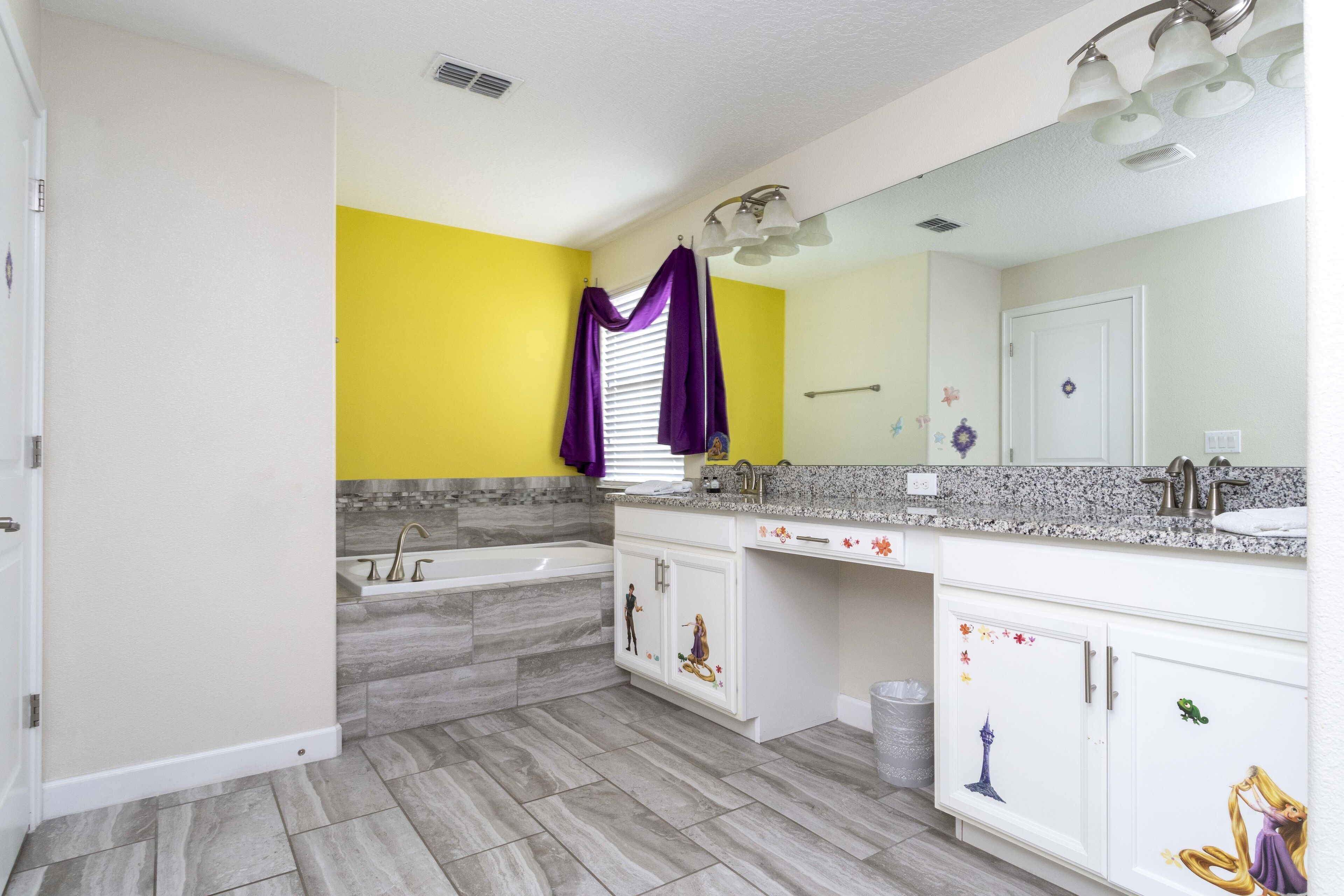 A bathroom with a bathtub, vanity, and a large mirror.