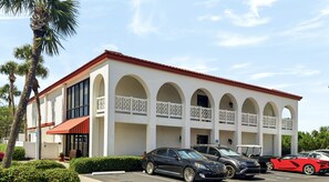 A building with a red roof, white walls, and multiple balconies with white railings. - 114 El Matador 1 Bedroom Condo by RedAwning (Fort Walton Beach)