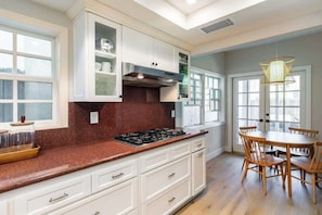 Beautifully finished kitchen featuring warm wood floors and a sunny dining area.