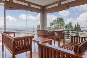 A balcony with wooden furniture and a view of the cityscape.