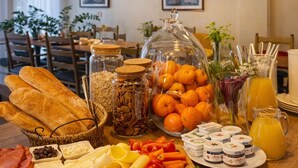 Un bufé de desayuno con diversas opciones de comida, como pan, frutas, verduras y salsas.