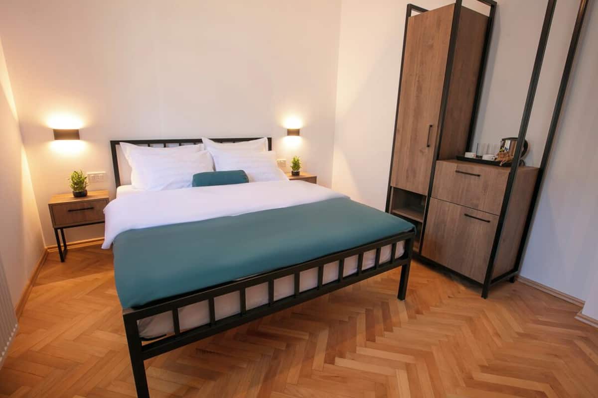 Une chambre à coucher avec un lit, des tables de chevet, une armoire et un miroir.
