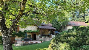 A stone house with a tiled roof, a covered patio, and a lawn. - Stunning Dordogne Holiday House and private heated pool. (Saint-Pompont)
